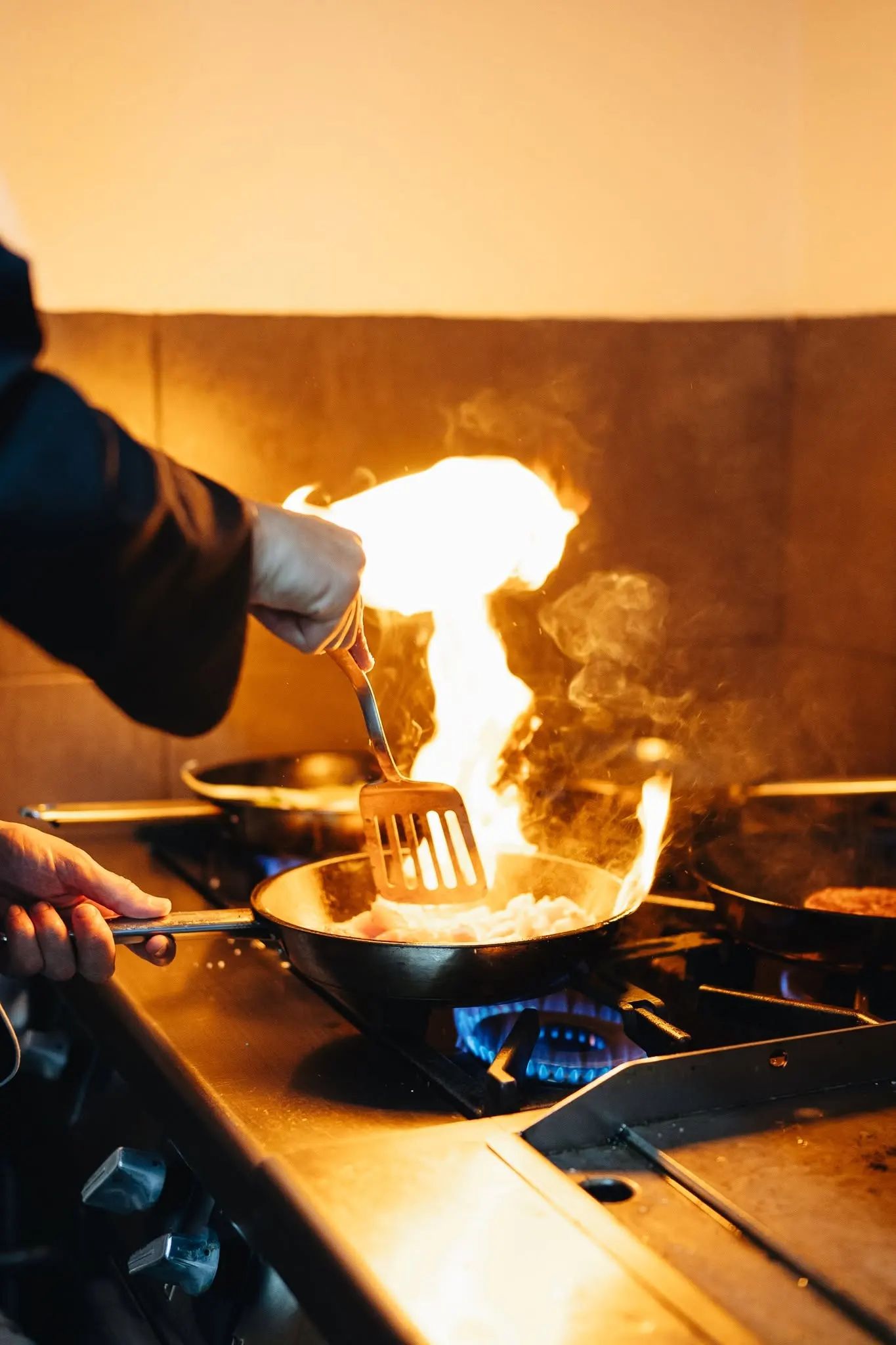 O chef a flamejar uma frigideira na cozinha do Quiosque da Relva