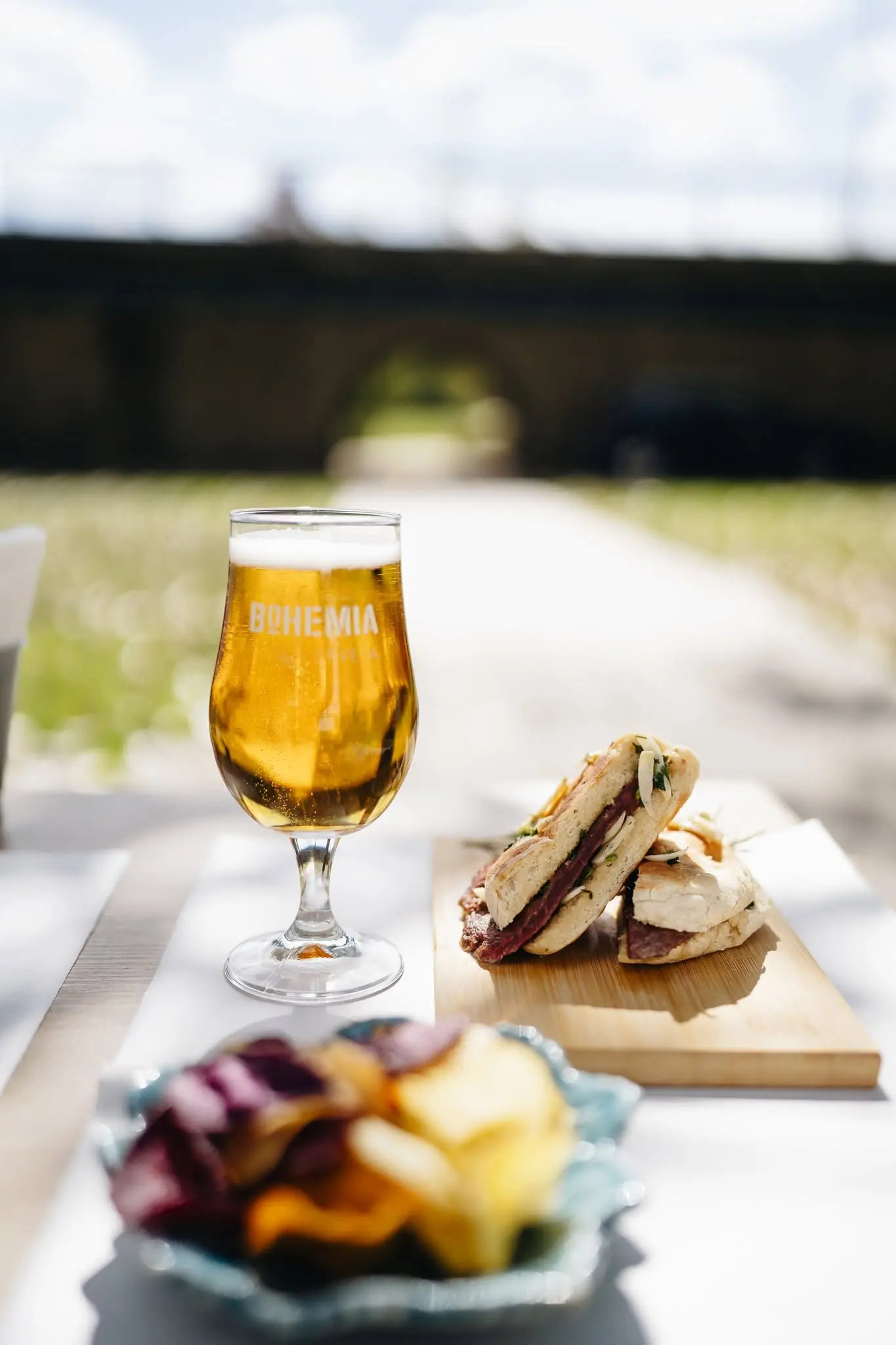 Petiscos e cerveja com a ponte de pedra ao fundo